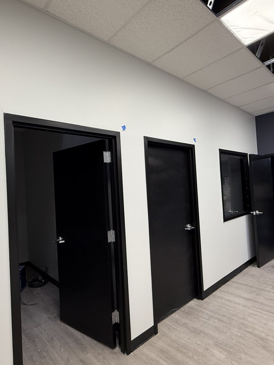 Completed corridor with painted two-tone walls, hollow metal doors and plank flooring